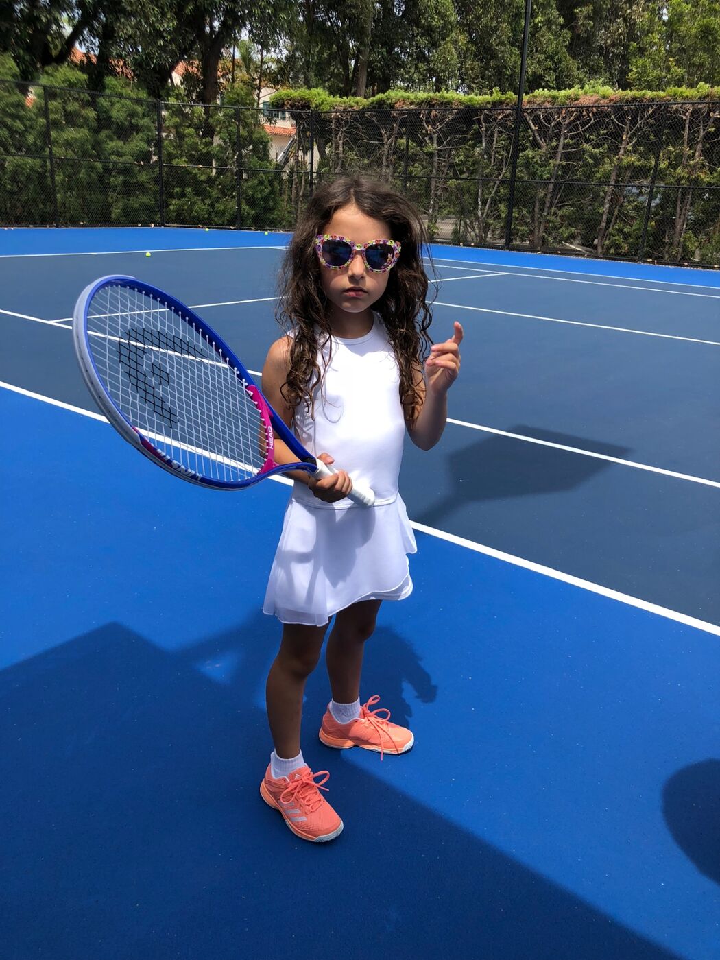 Gabi pointing at the camera on a blue court