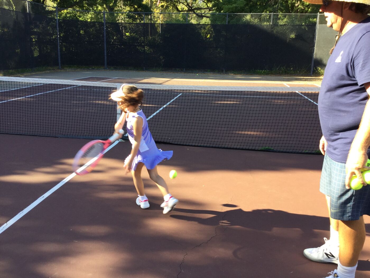Young Gabi swinging through a forehand on court